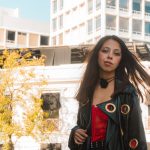 Stylish portrait of a young woman in Heroica Puebla de Zaragoza, against urban architecture.